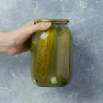 female hand holding pickle jar air